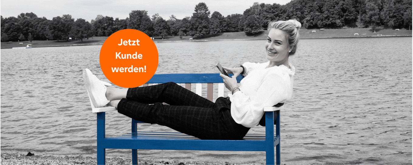 Eine Frau liegt auf einer Holzbank, im Hintergrund ein See.