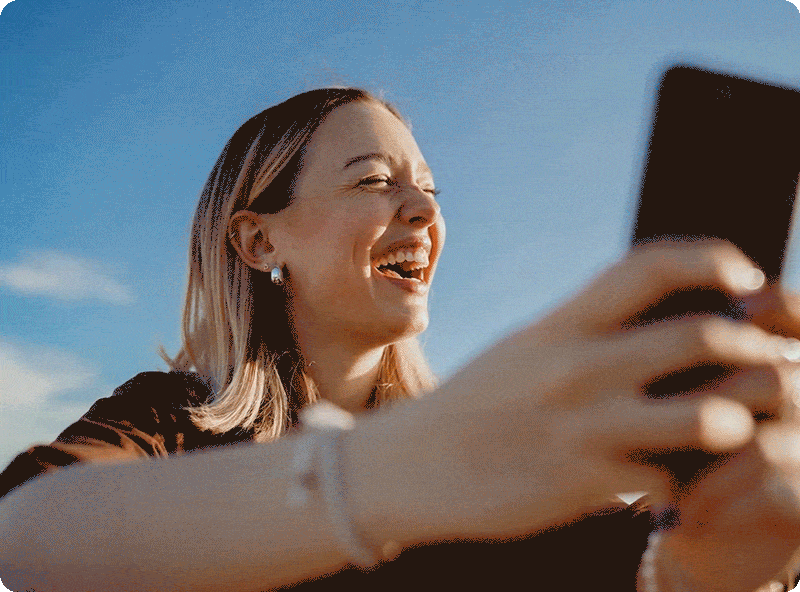 Frau hält Smartphone in der Hand und lacht
