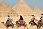 Menschen reiten auf Kamelen im Hintergrund Pyramiden
