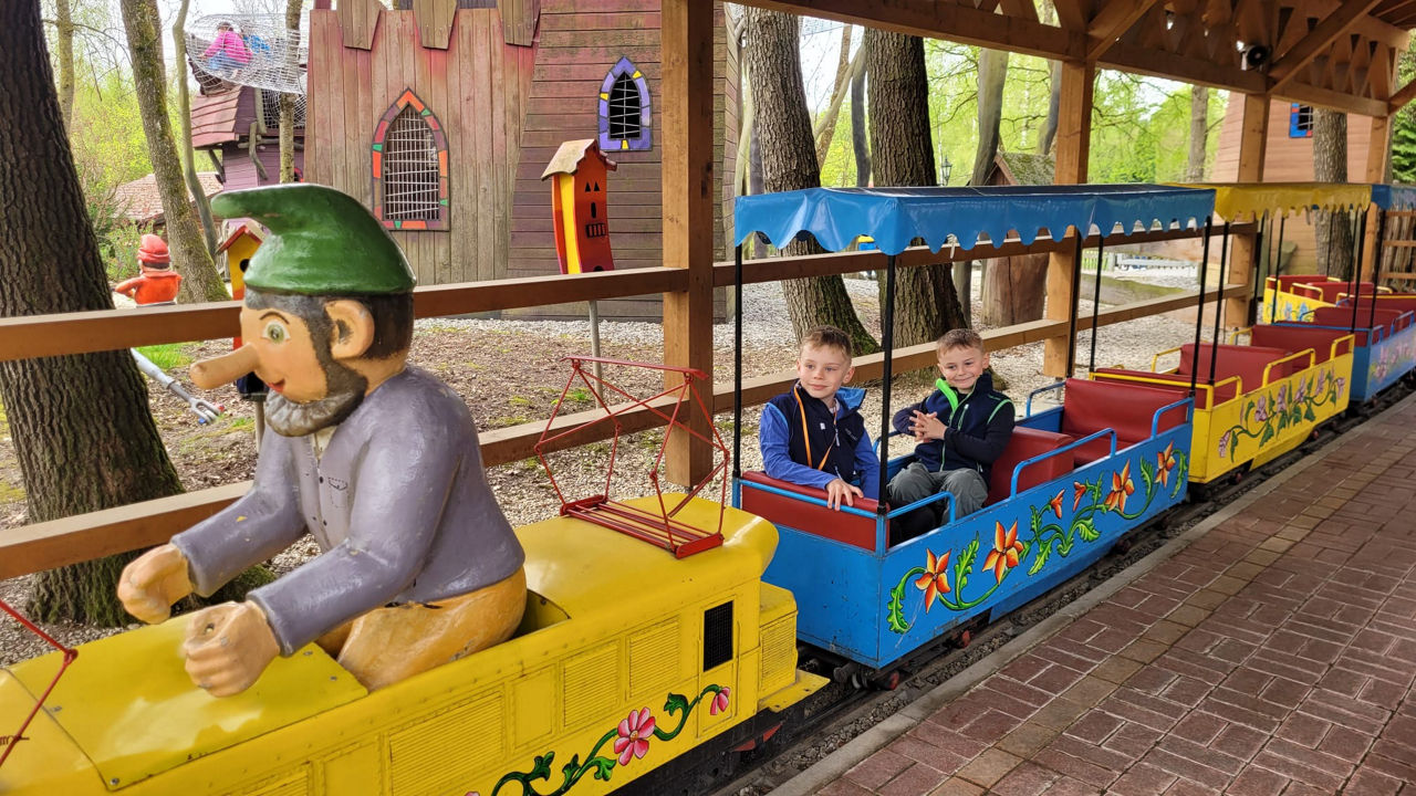 Kinder sitzen in einer Märchenachterbahn