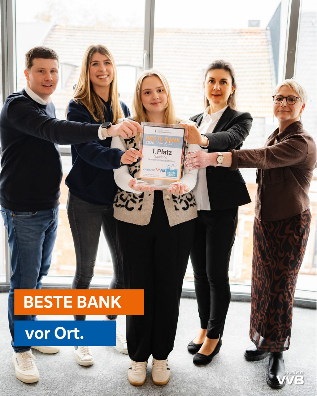 4 Damen und 1 Herr im Casual Business Outfit halten die Auszeichnung Beste Bank 2026 hoch