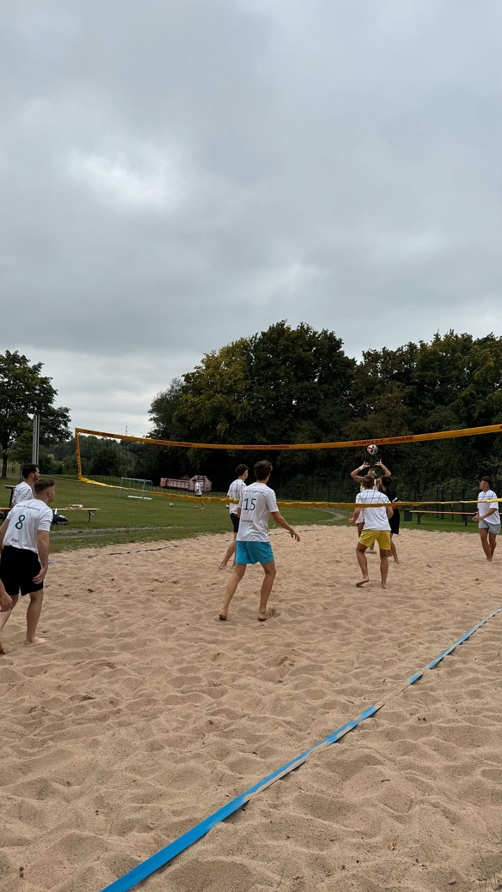 Beachvolleyballspiel bei bewölktem Himmel.
