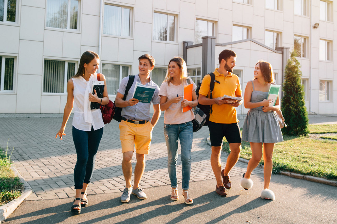 Fünf freundliche Studenten gehen spazieren