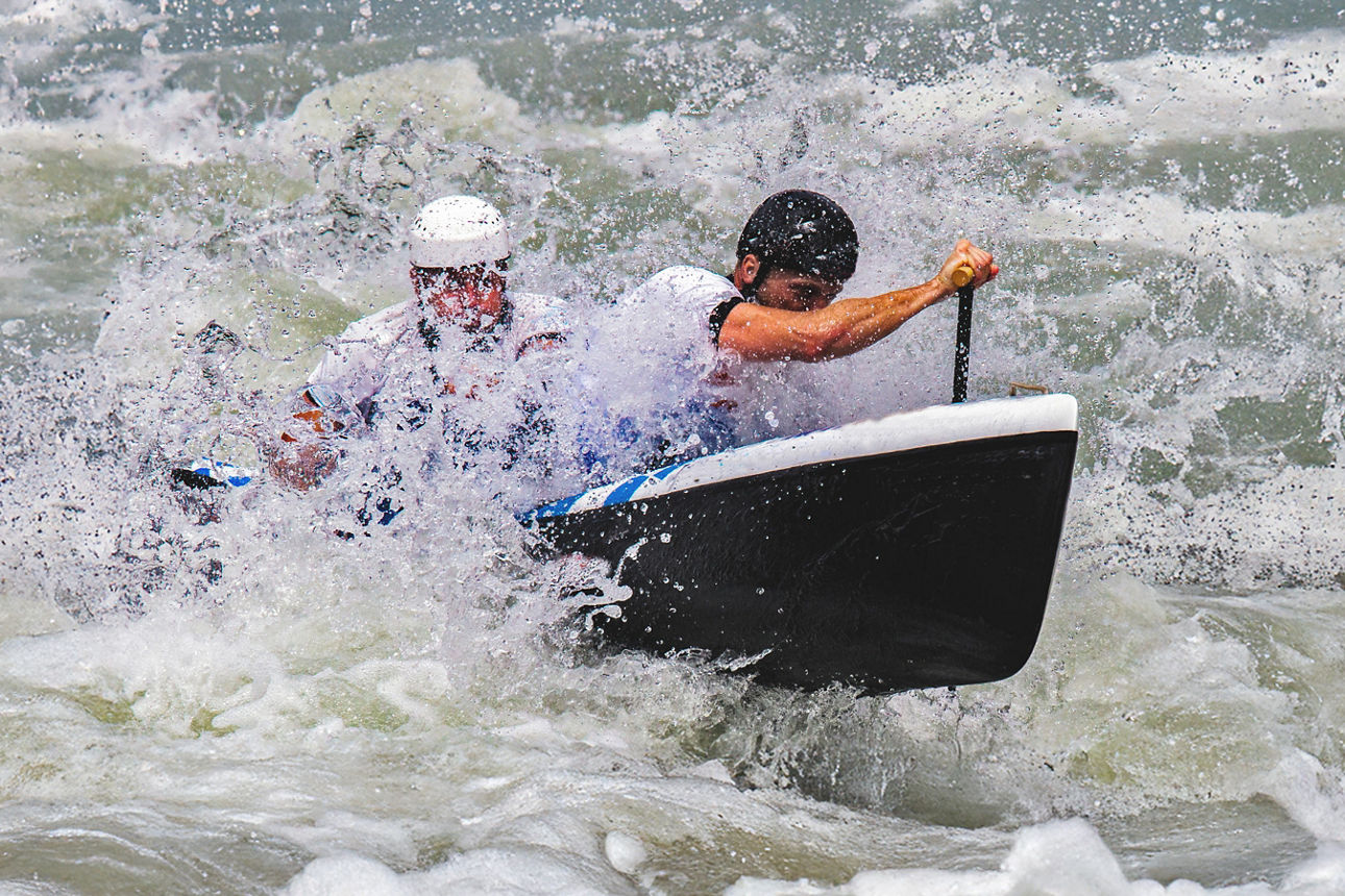 Zwei Männer bei einer Wildwasserfahrt in einem Kanu