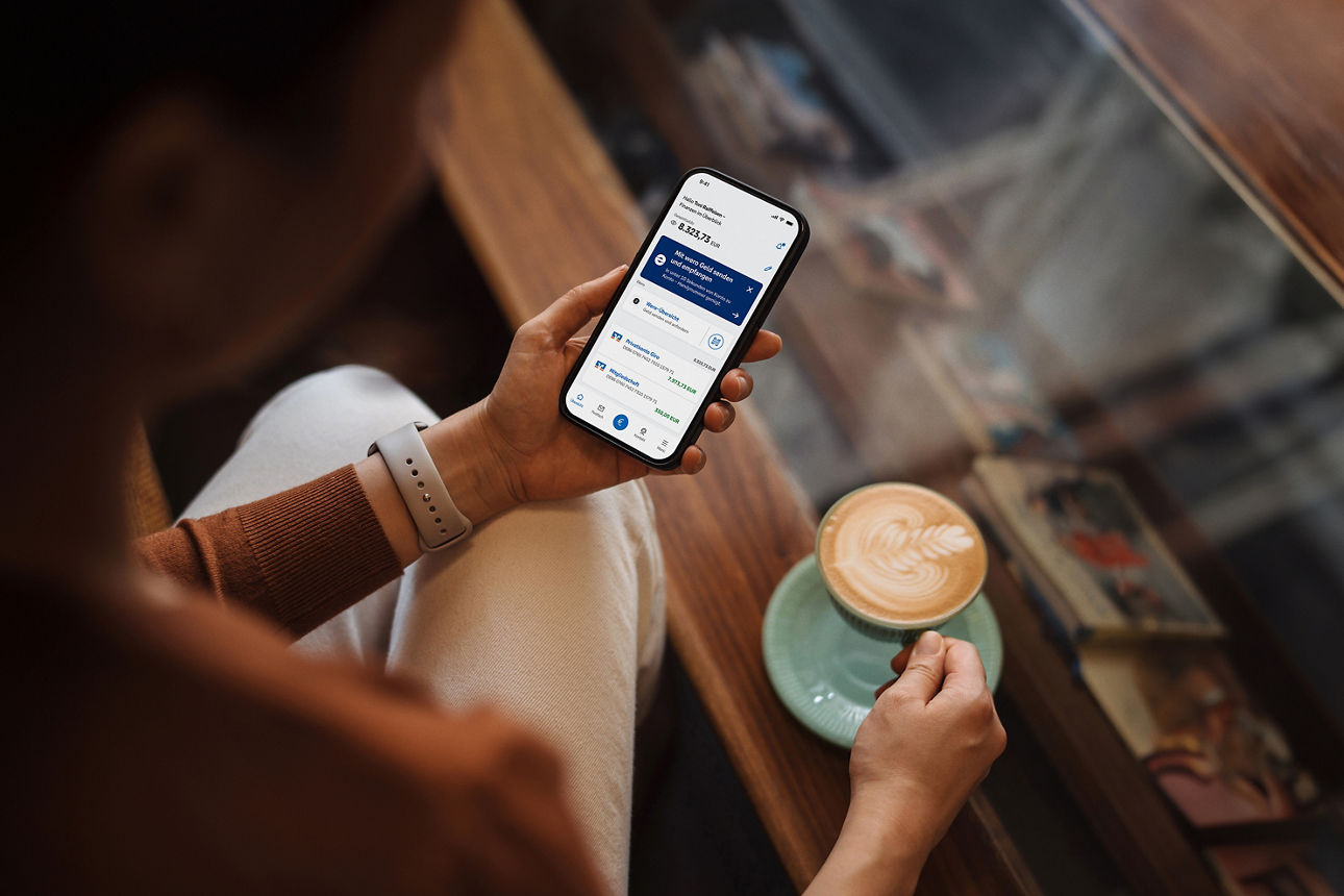 Frau schaut auf die VR Banking App in ihrem Smartphone