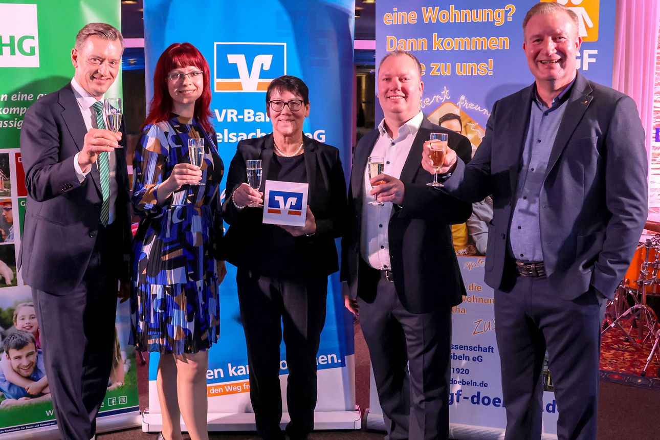 Drei Herren und zwei Frauen mit Getränk in der Hand symbolisiseren den gemeinsamen Empfang