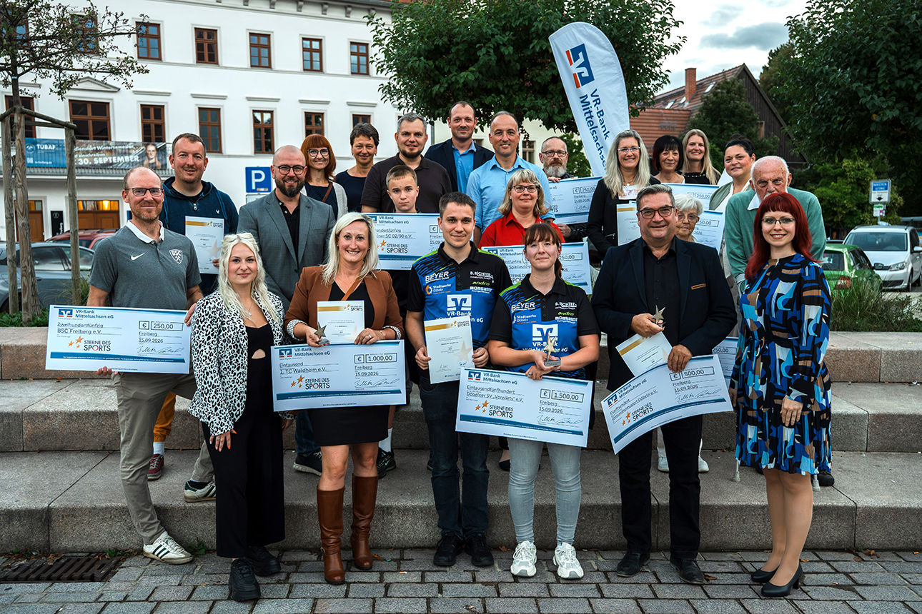 Gewinner halten Pokale, Urkunden und Schecks hoch