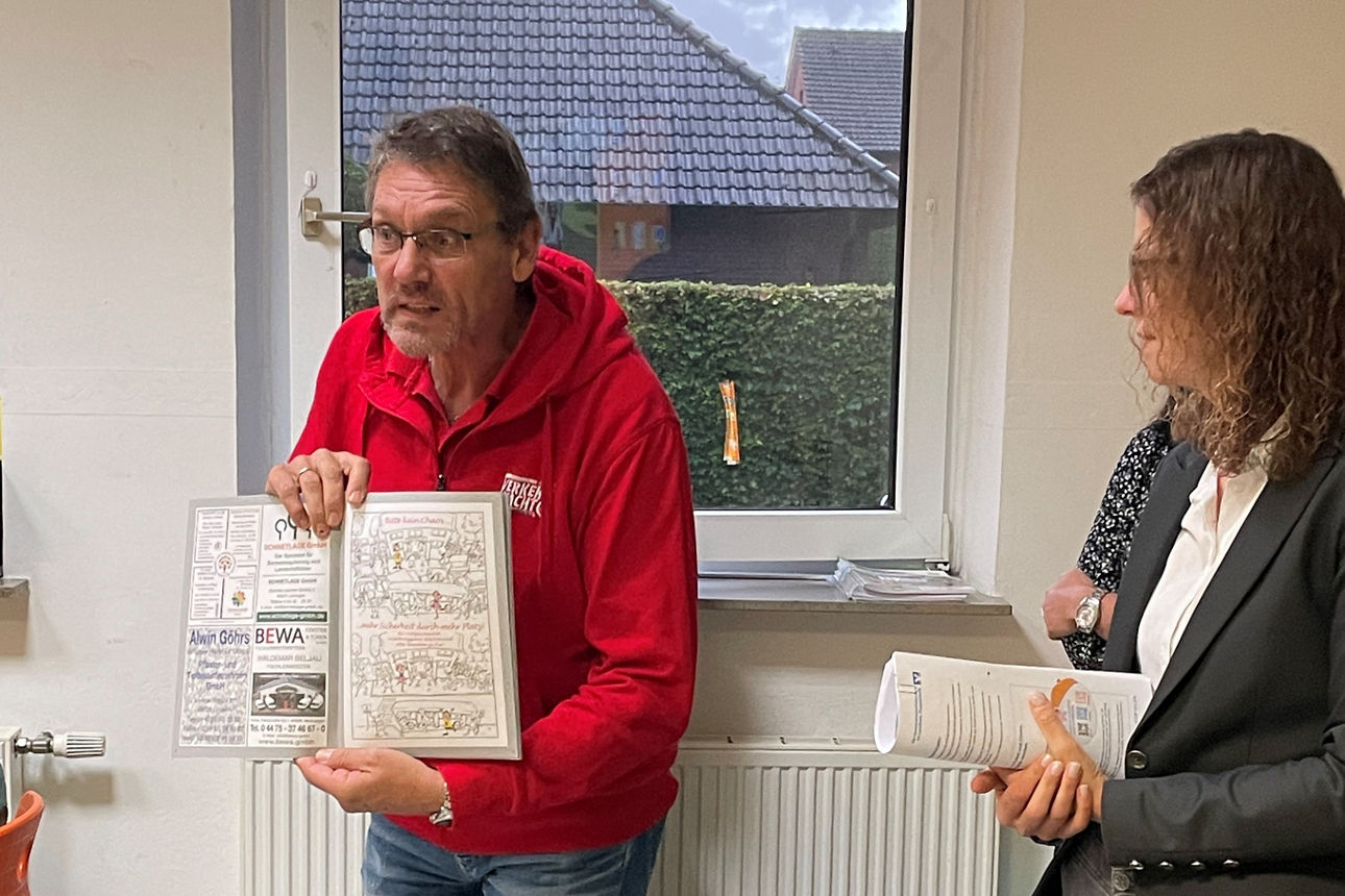 Herr Wach erklärt Kindern etwas zum Straßenverkehr