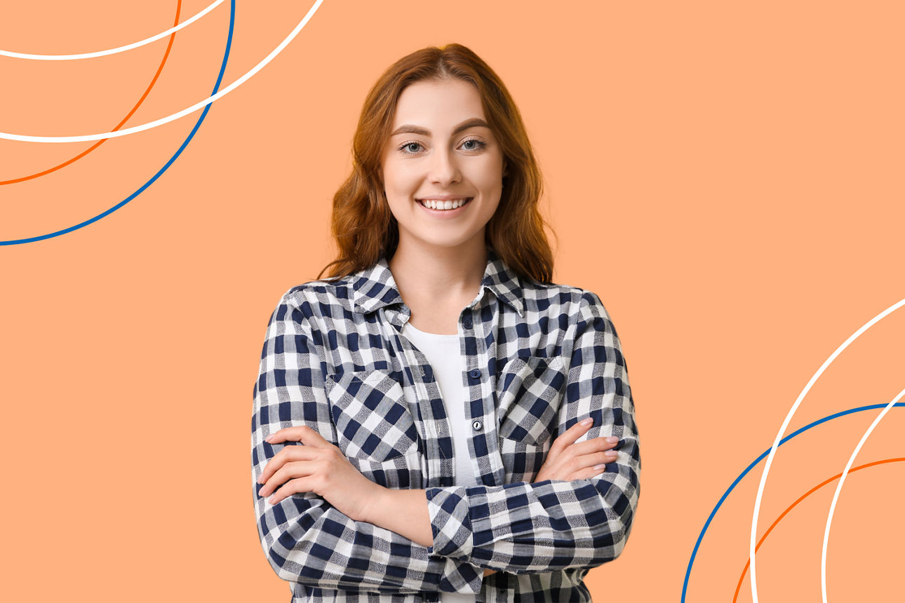 Eine selbstbewusste Frau mit kariertem Hemd lächelt vor einem orangefarbenen Hintergrund.