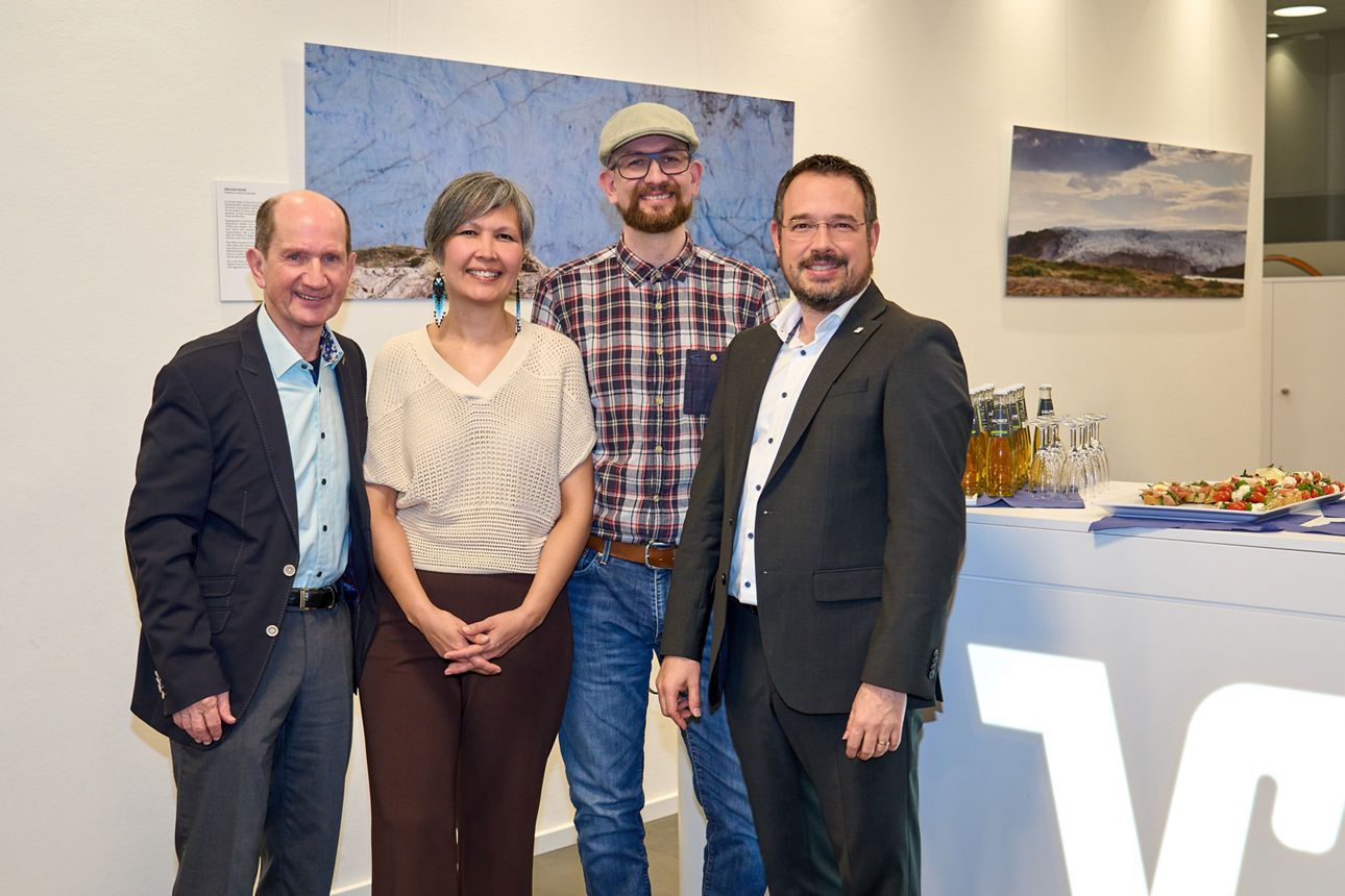 Vier Personen bei der Eröffnung der Dauner Fototage vor Landschaftsfotografien in Galerie