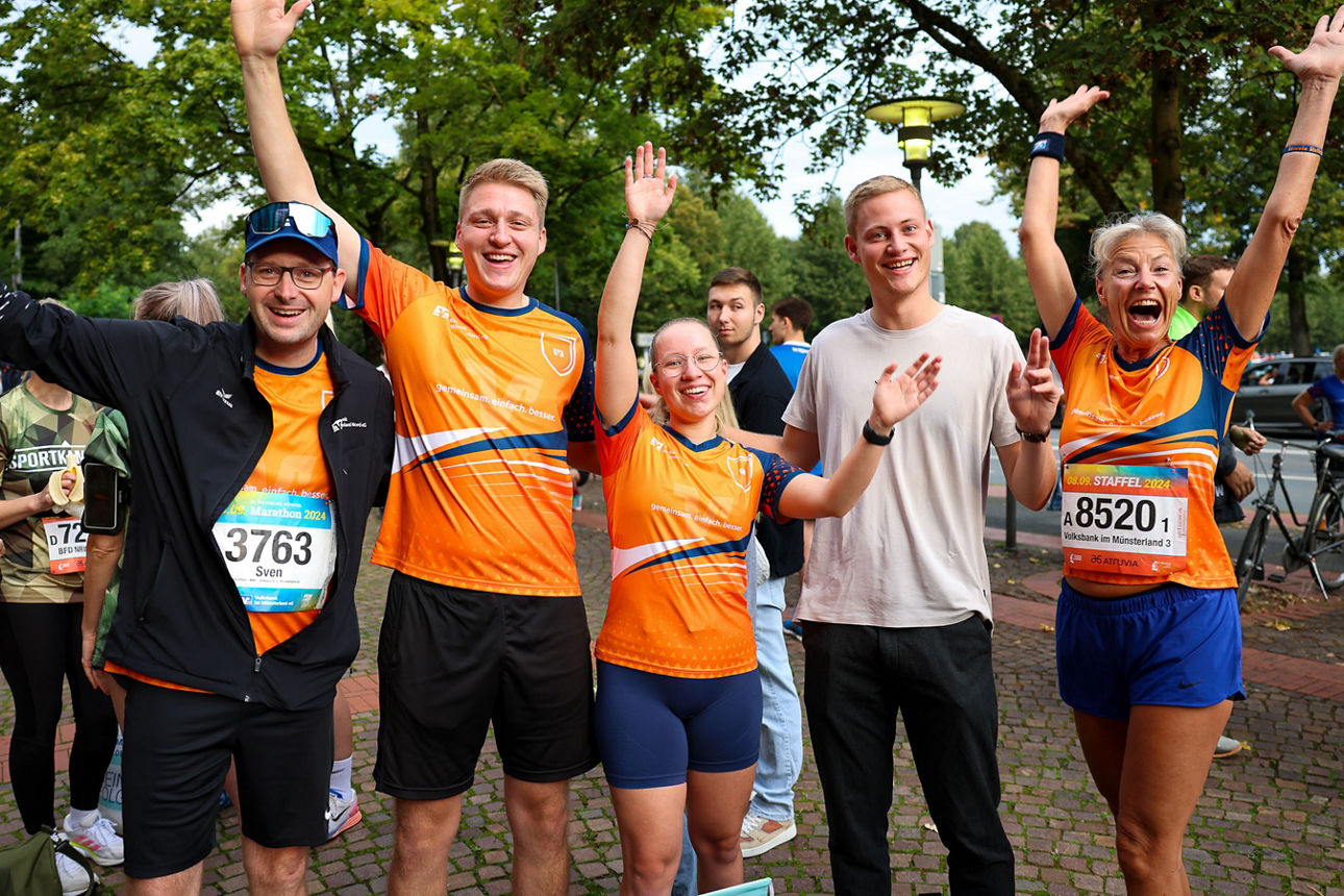 Ein Team der Volksbank im Münsterland hat am Staffellauf teilgenommen und jubelt in orangenen Trikots