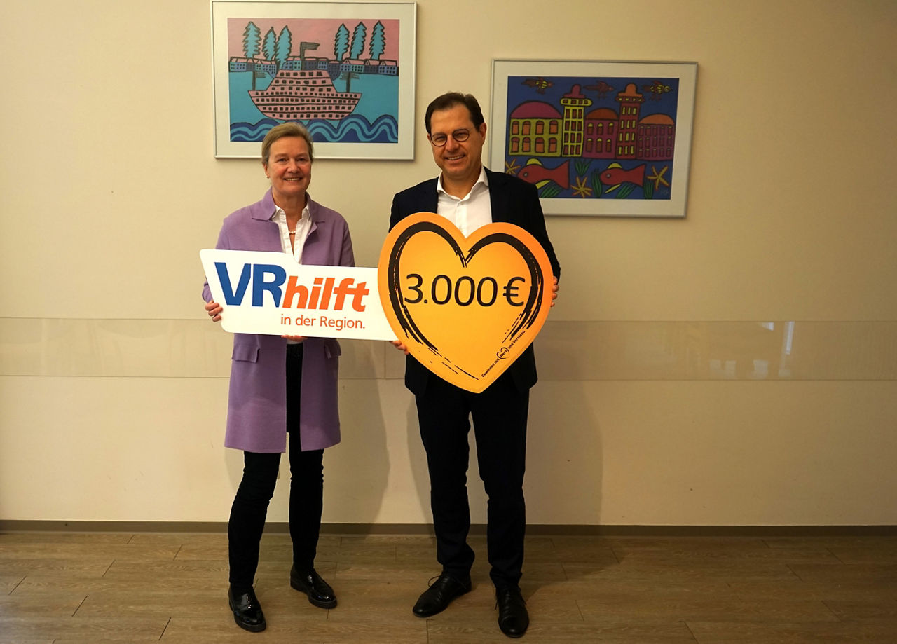 Das Bild zeigt einen Mann und eine Frau. Sie halten ein Schild mit der Aufschrift 3000 €.