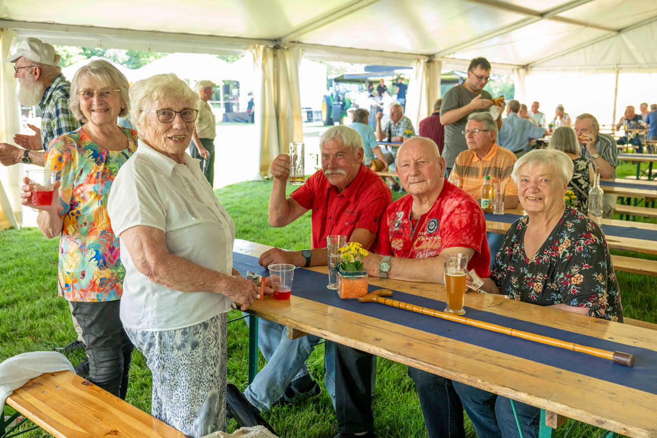 Unsere Kunden am Biertisch lächeln in die Kamera