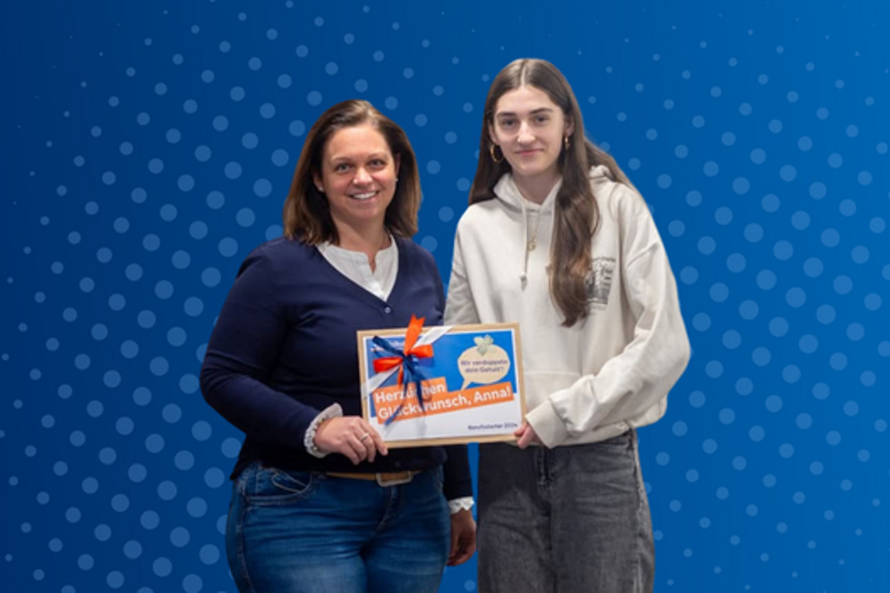 Eine Beraterin übergibt der Kundin symbolisch das doppelte Gehalt