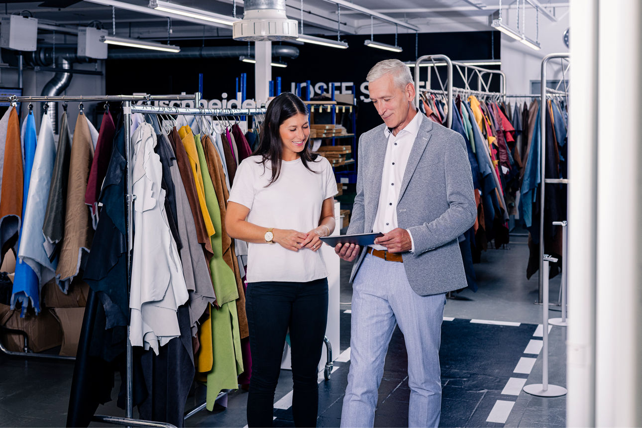 Frau mit zwei Männern im Gespräch in einer Werkstatt