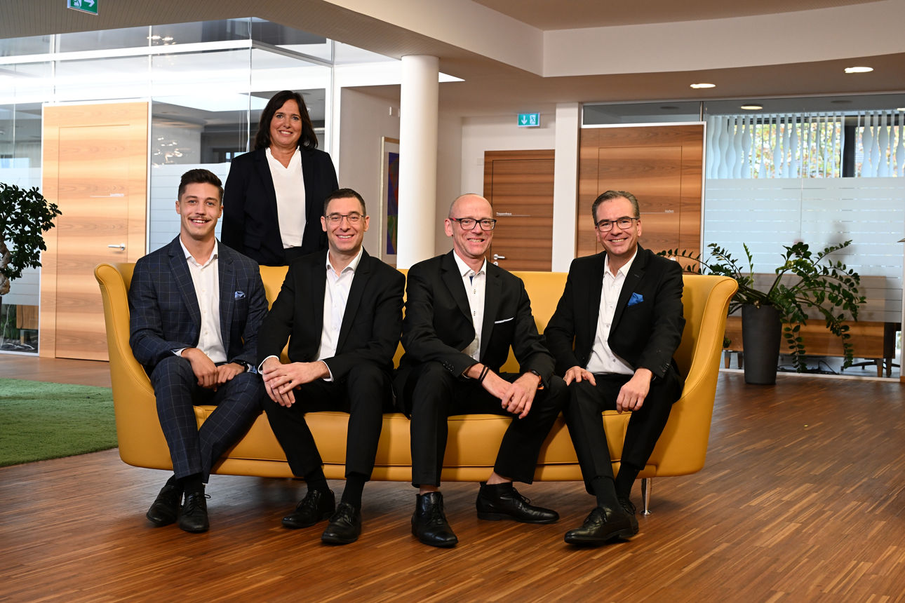 Das Private Banking Team der VR SüdBank eG. Frauen und Männer in Business-Kleidung sitzen in einem modernen Foyer.