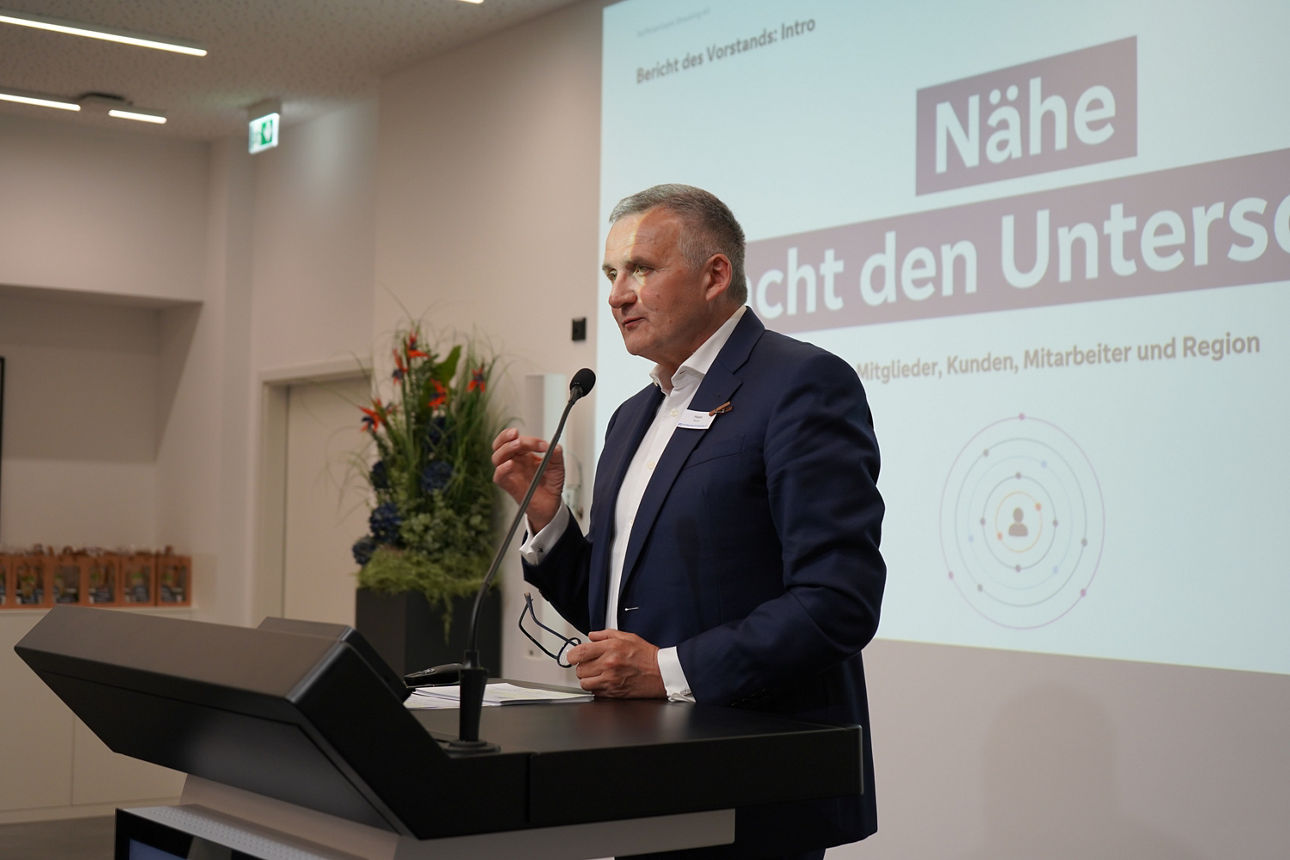 Ein Mann ist vor einer Beamerleinwand zu sehen