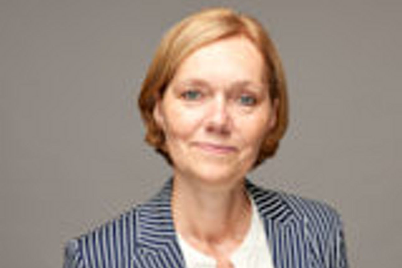 Eine Frau trägt einen gestreiften Blazer über einem weißen Hemd