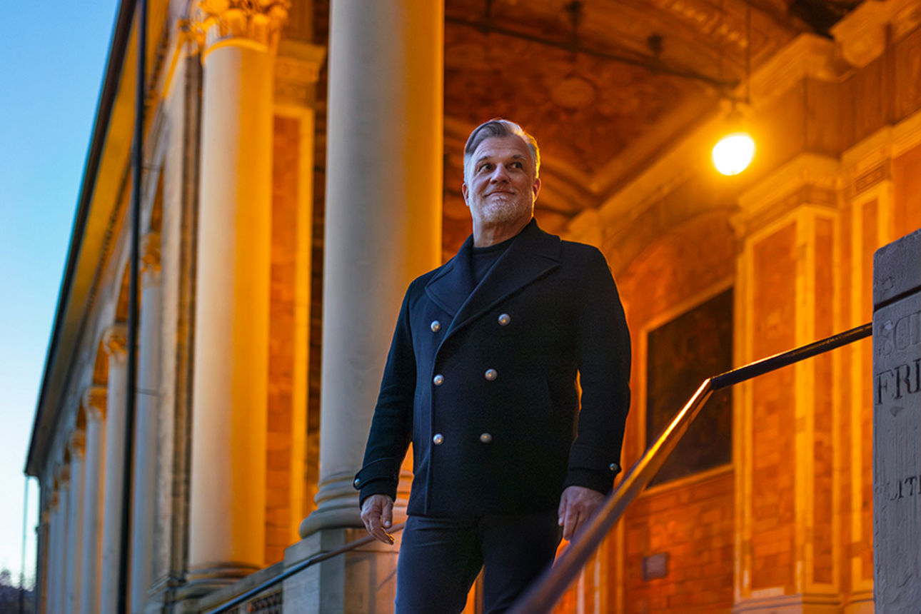 Marc Marshall auf einer Treppe vor einem historischen Gebäude