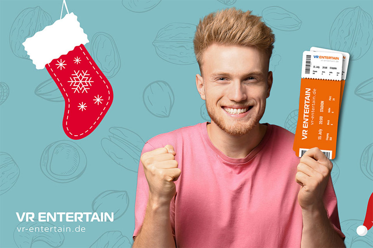 Lächelnder Mann mit fest zusammengedrückten Händen hält in einer Hand Tickets fest