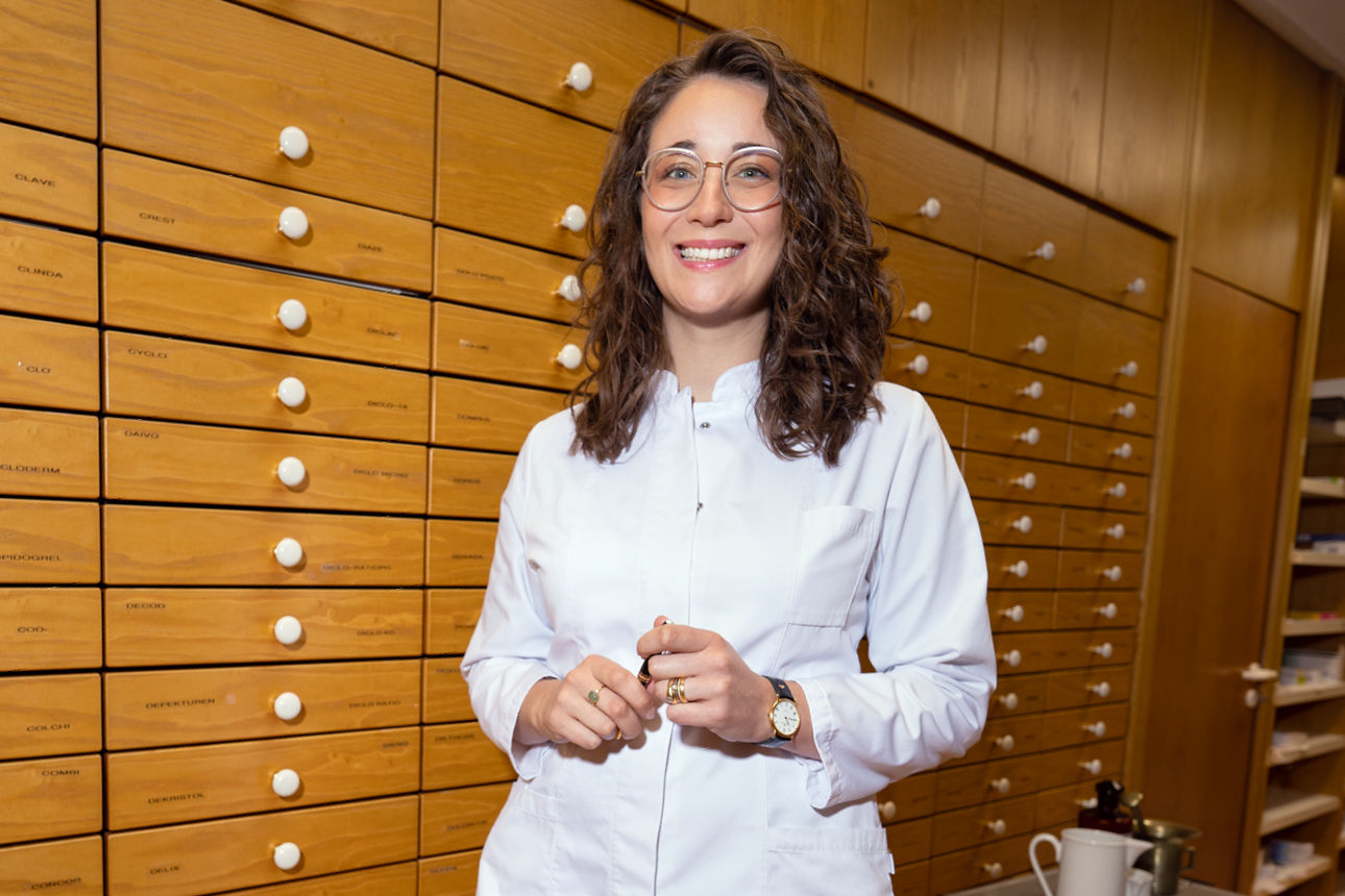 Junge Apothekerin vor einem Apothekerschrank