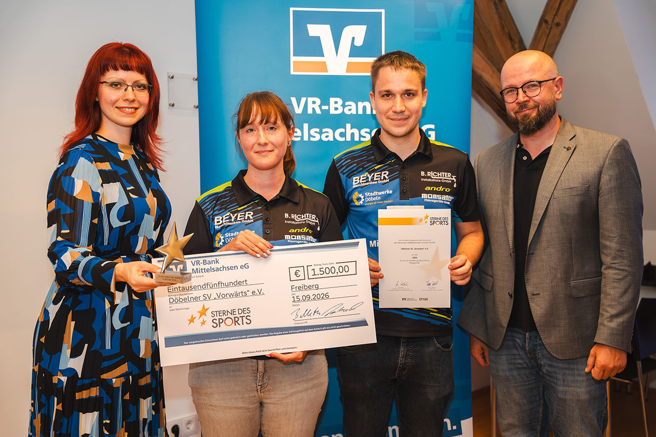Zwei Männer und zwei Frau bei der Vergabe des 1. Platzes mit Siegerpokal und Scheck