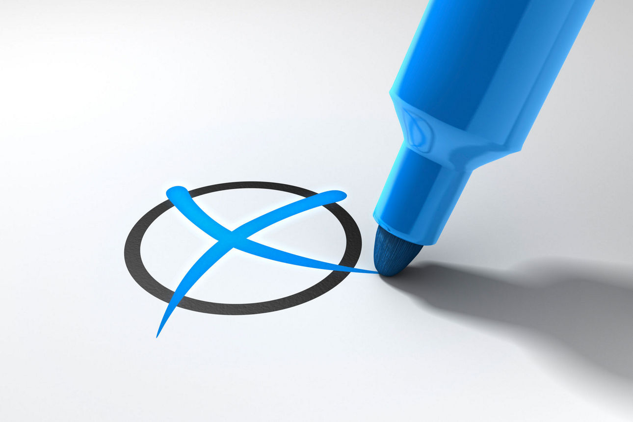 Ein blauer Filzstift macht ein Kreuz in einem Kreis