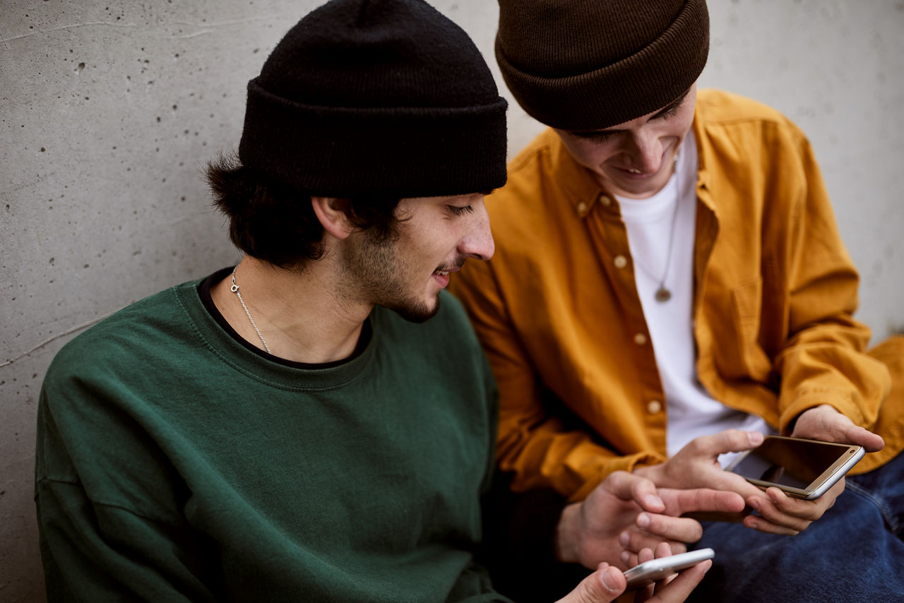 Zwei Jugendliche im Bus schauen auf ein Smartphone