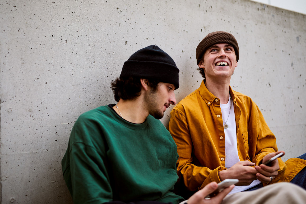 Jugendliche Skater sitzen an der Wand