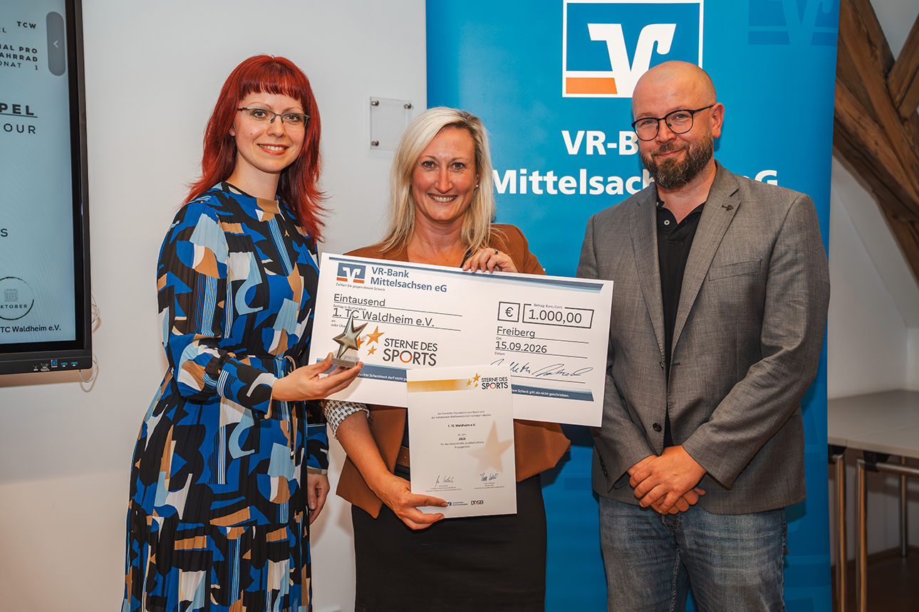 Ein Mann und zwei Frauen bei der Vergabe des 2. Platzes mit Siegerpokal und Scheck