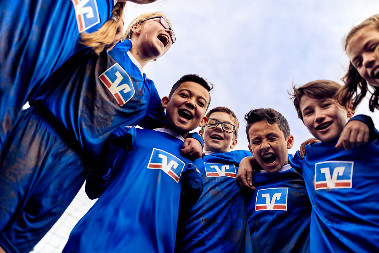 Junge Kinder in Trikots freuen sich beim Fußball