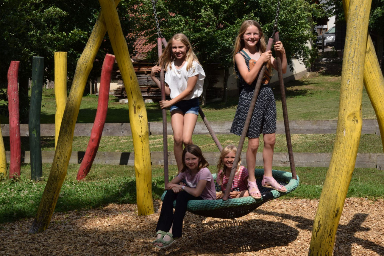 Vier Mädels auf einer Schaukel.