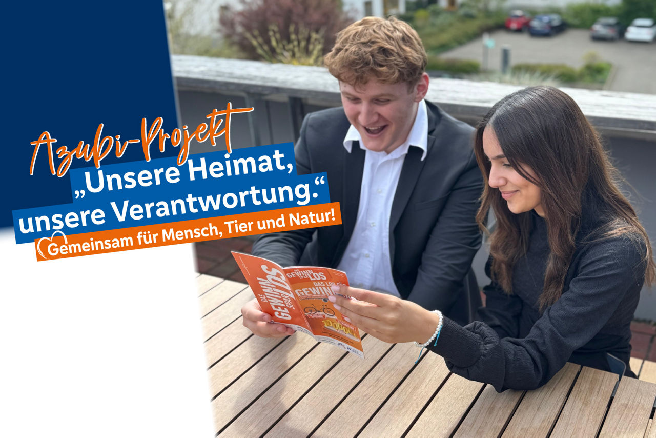 2 Azubis sitzen an einem Tisch und lesen den Gewinnsaprflyer