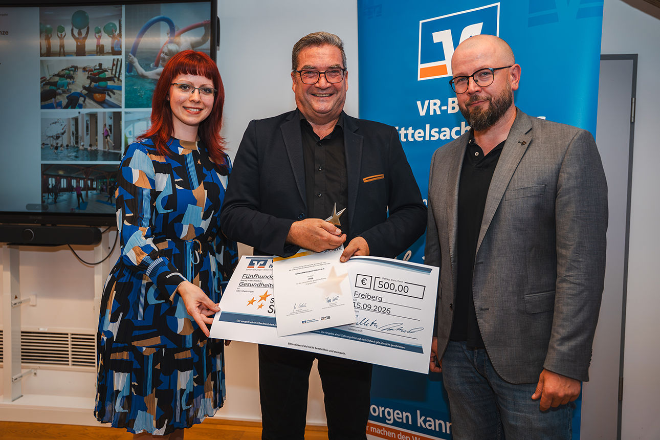 Zwei Männer und eine Frau bei der Vergabe des 3. Platzes mit Siegerpokal und Scheck