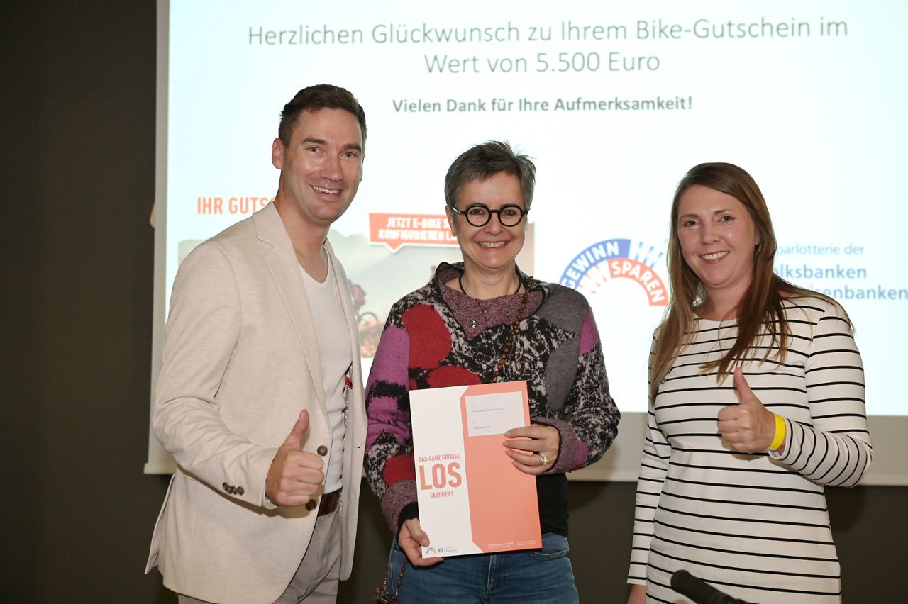 Die Gewinnern strahlt mit Bike-Gutschein in den Händen in die Kamera