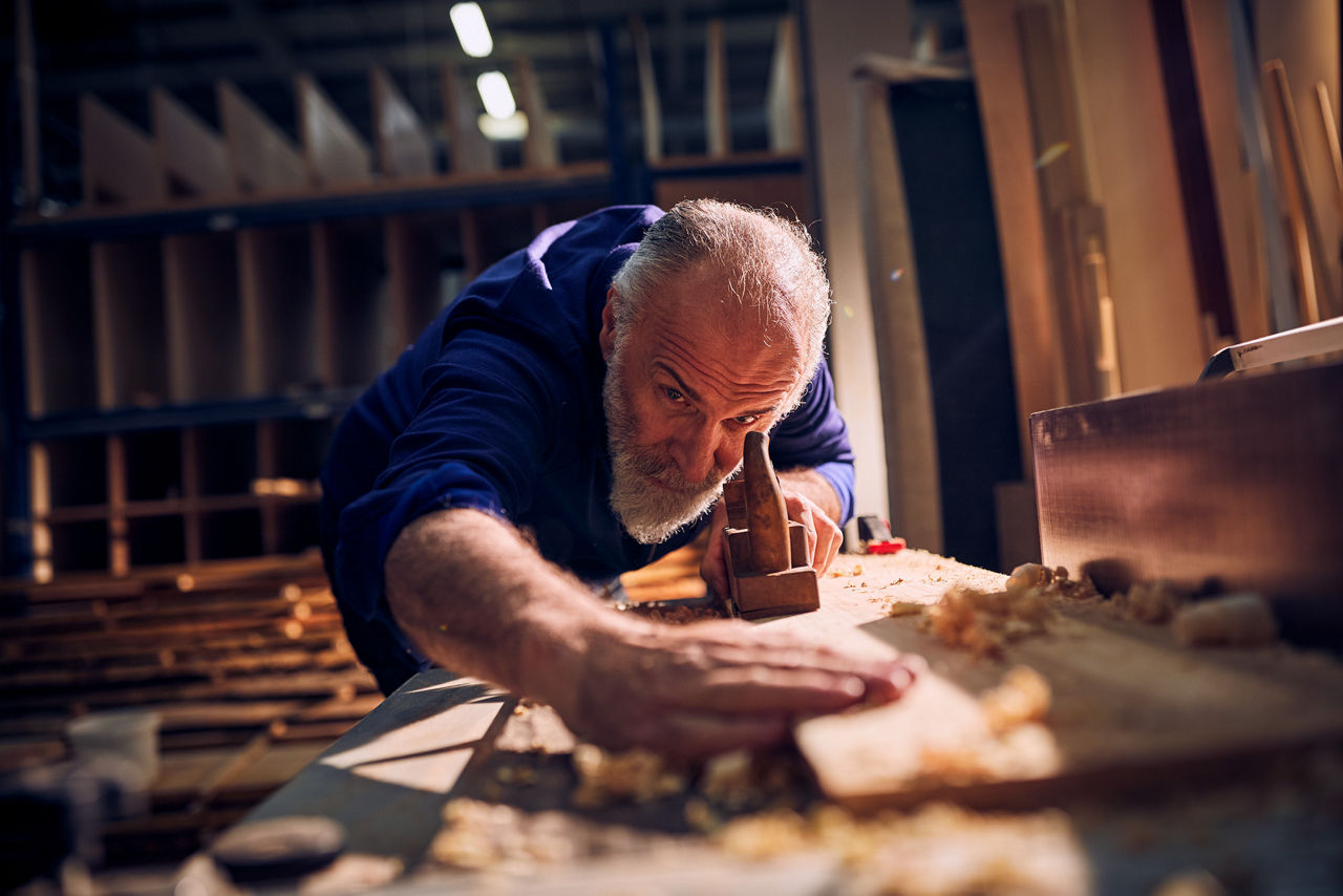 Älterer Handwerker bei der Arbeit in der Holzwerkstatt