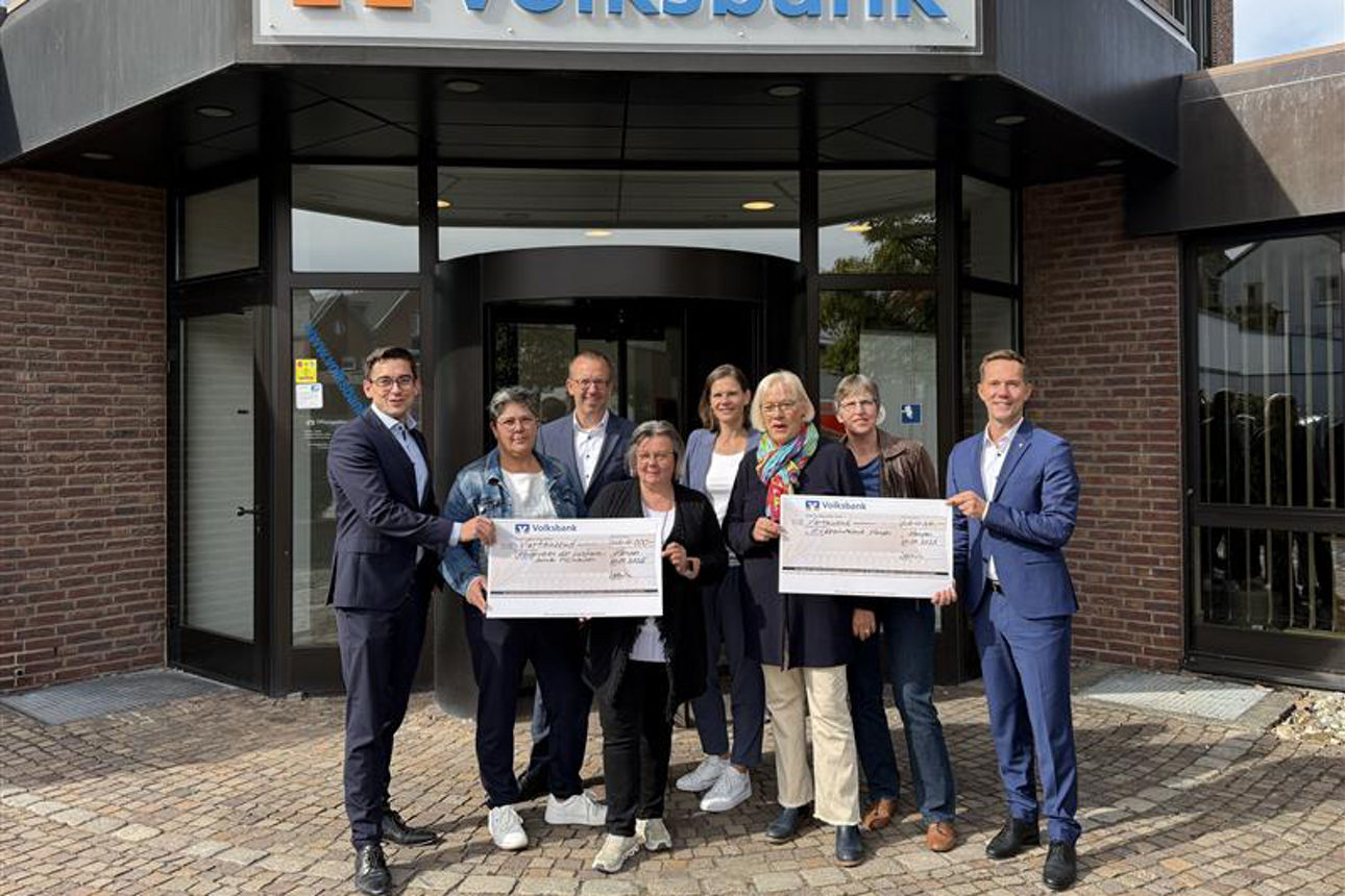 Eine Scheckübergabe vor einer Filiale.