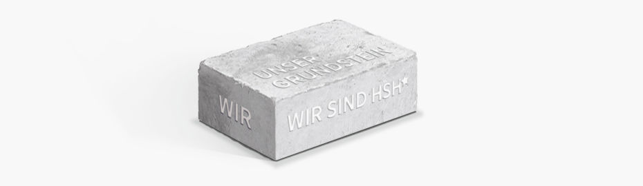 Ein grauer Baustein mit den Aufschriften: Unser Grundstein, Wir, Wir sind HSH
