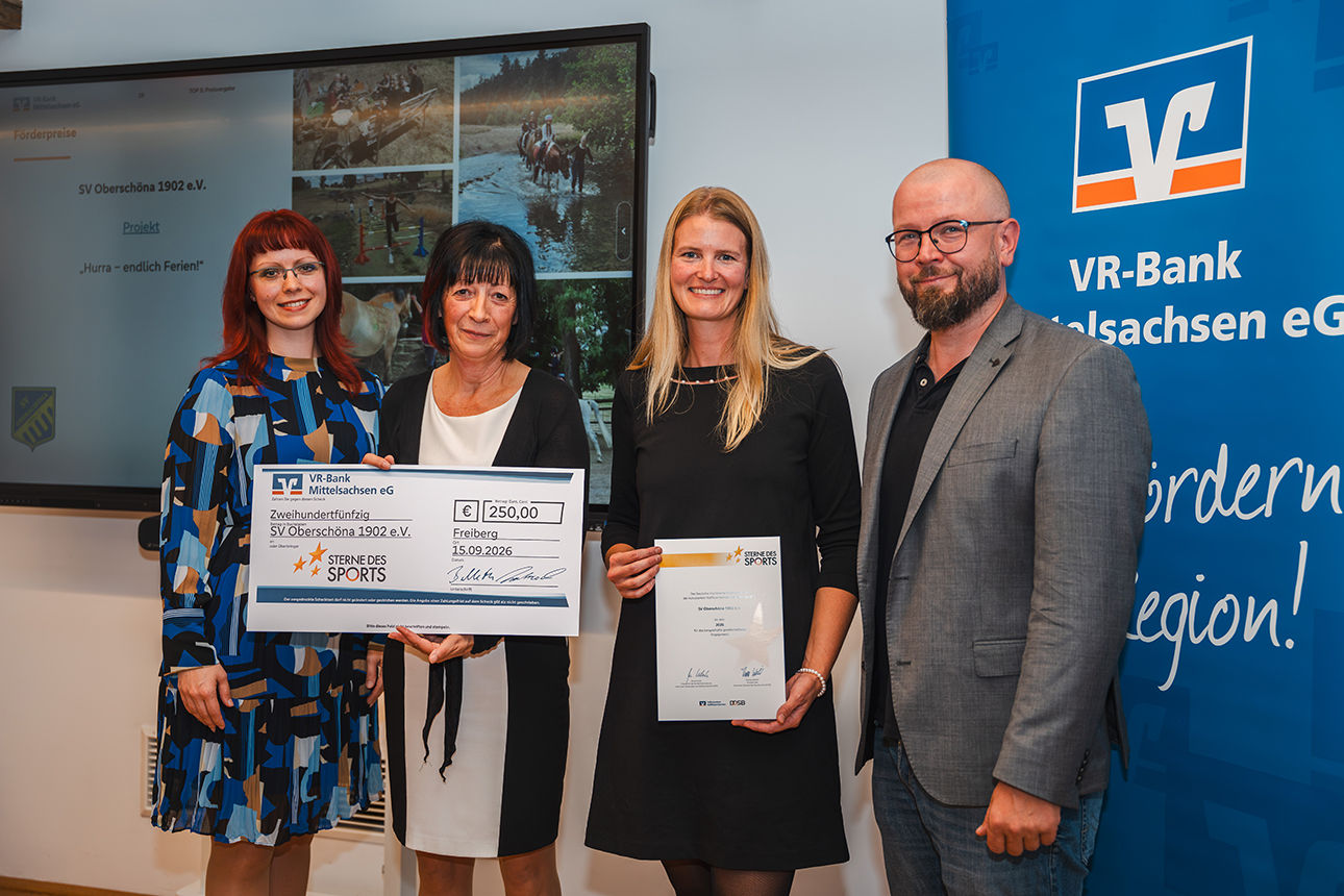 Ein Mann und drei Frauen bei der Vergabe des Förderpreises mit Urkunde und Scheck