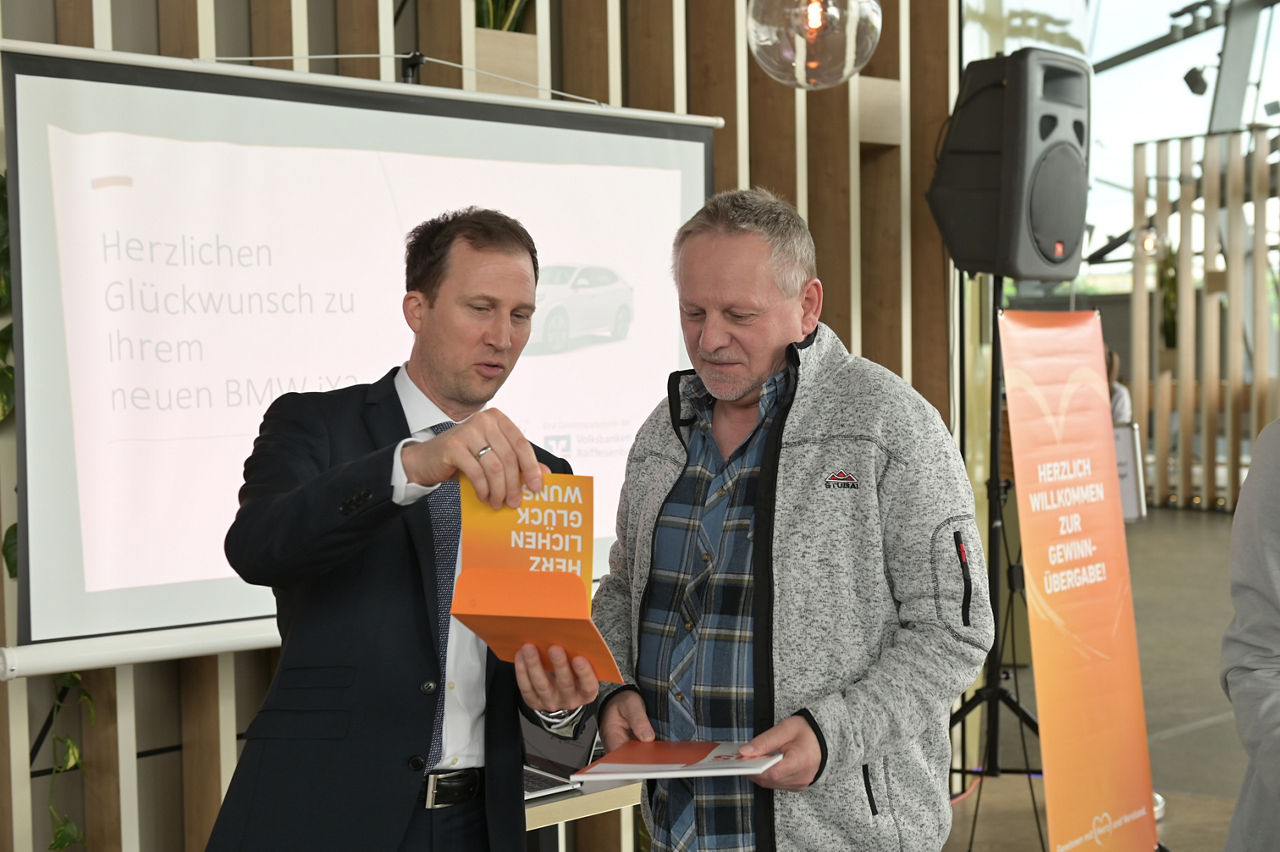 Matthias Morgenroth bekommt die Unterlagen für sein neues Auto überreicht