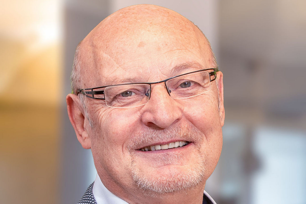 Ansprechpartner Gerhard Stooß. Ein Mann mit Brille und Anzug.