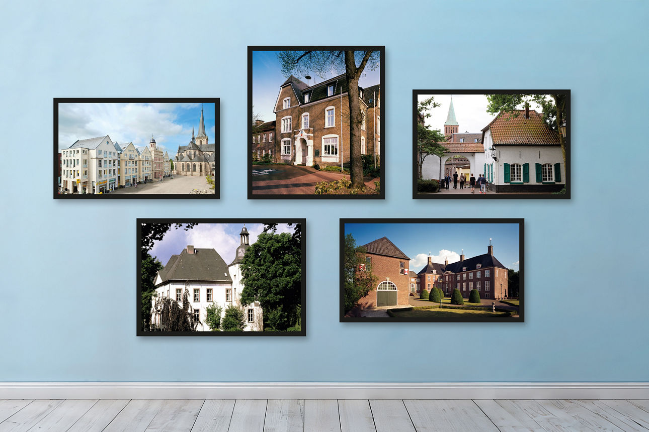 Regionale Bilder aus Dinslaken, Hamminkeln, Hünxe, Voerde und Wesel hängen in schwarzen Bilderrahmen auf einer blauen Wand.