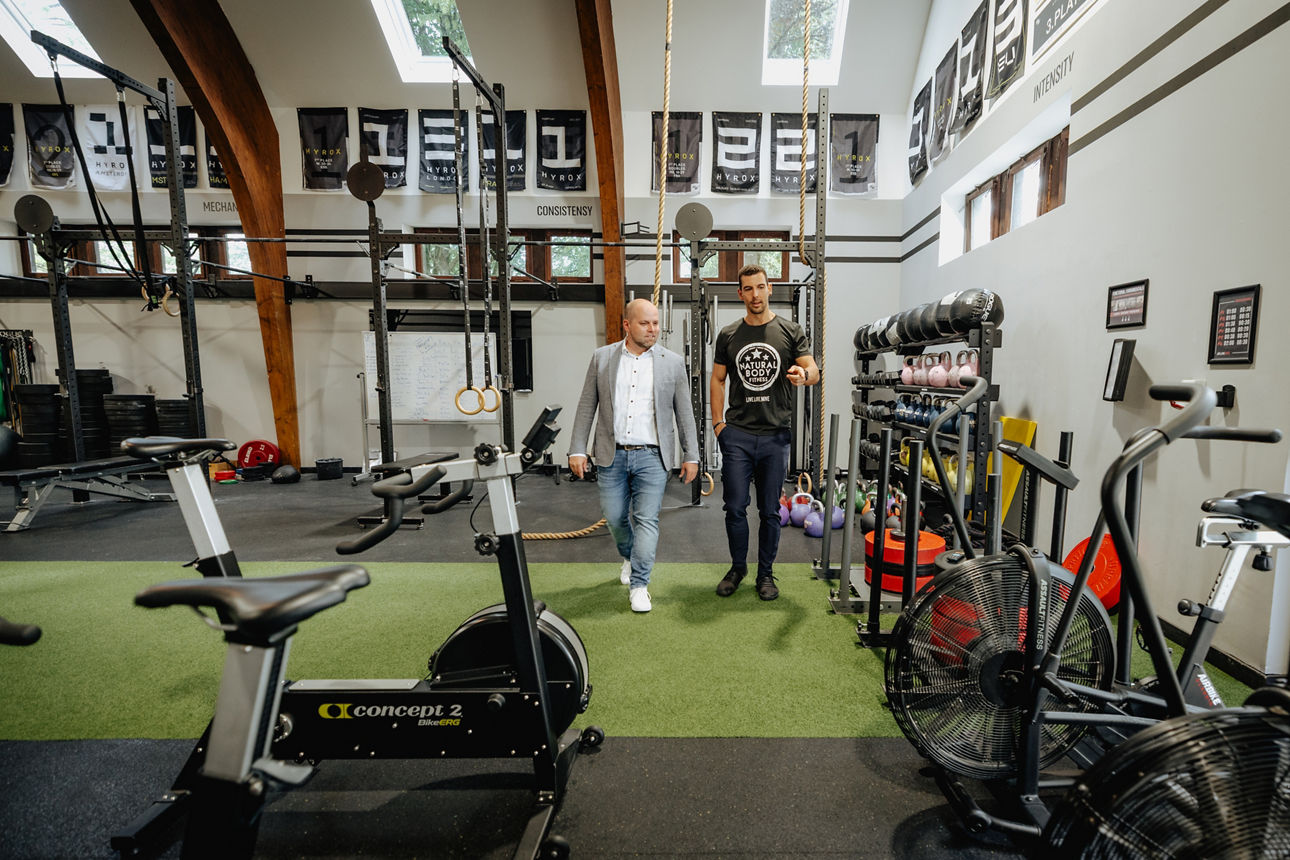 Volksbank in Südwestfalen Berater mit Kunden in moderner Fitnesshalle