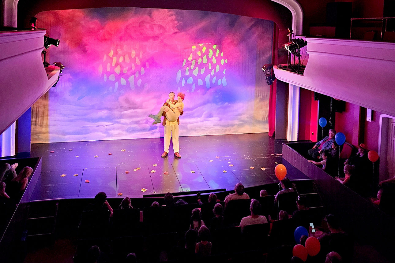 Die Zuschauer verfolgen im Hauptsaal des Theaters dem Programm auf der Bühne