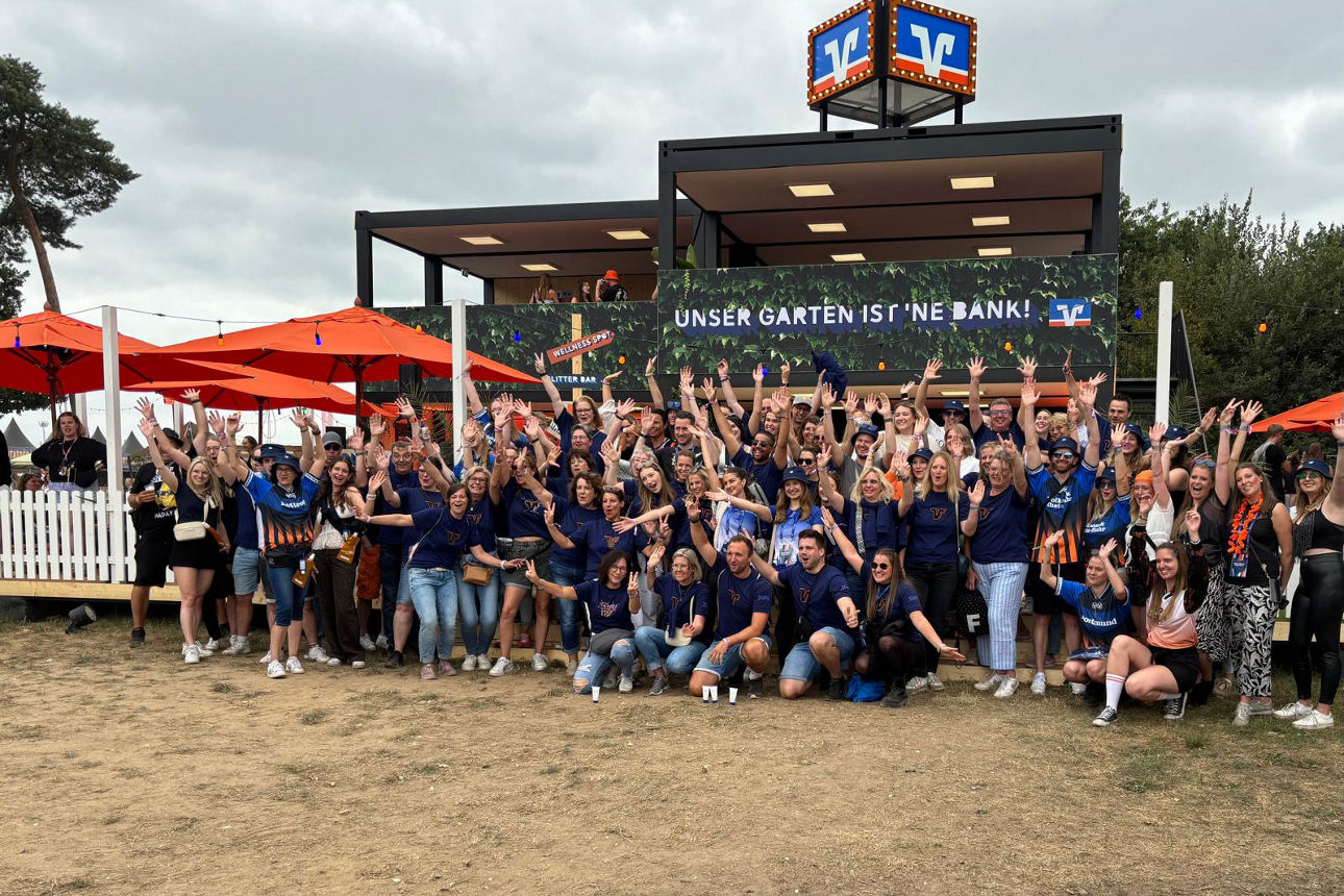 Gruppenfoto von Volksbank-Mitarbeiterinnen und Mitarbeitern aus ganz Deutschland vor dem BVR-Garten