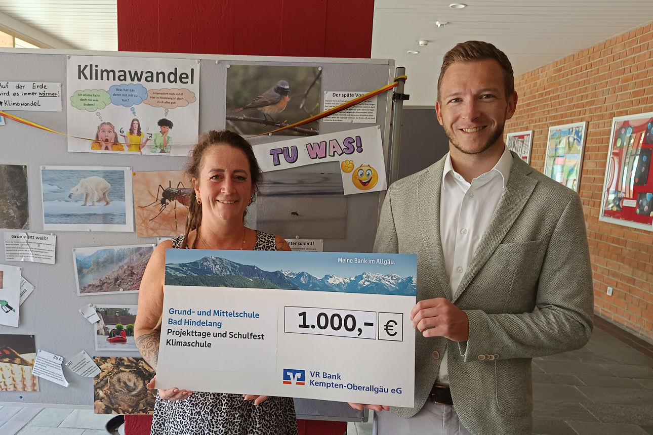 Schulförderpreis Grund- und Mittelschule Bad Hindelang - Schulleiterin und Bankmitarbeiter halten den Spendenscheck