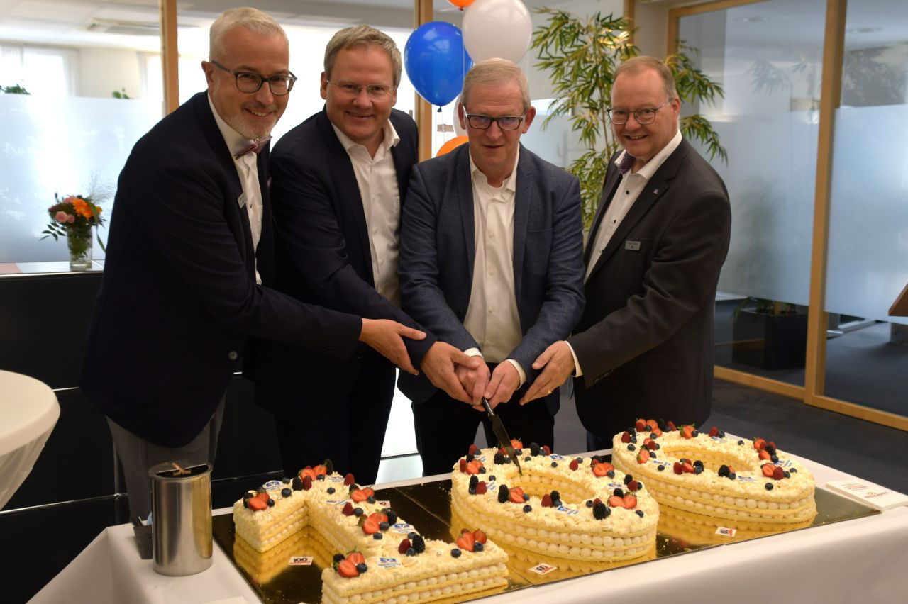 Der Vorstand schneidet die Torte zusammen mit dem Bürgermeister an