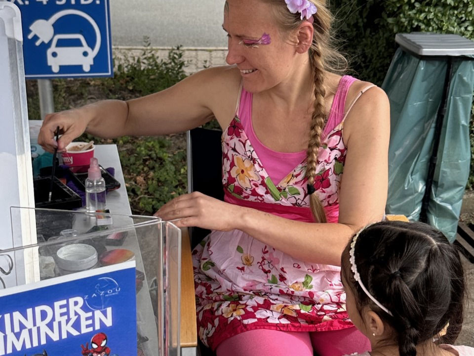 Eine Frau schminkt ein Kind 