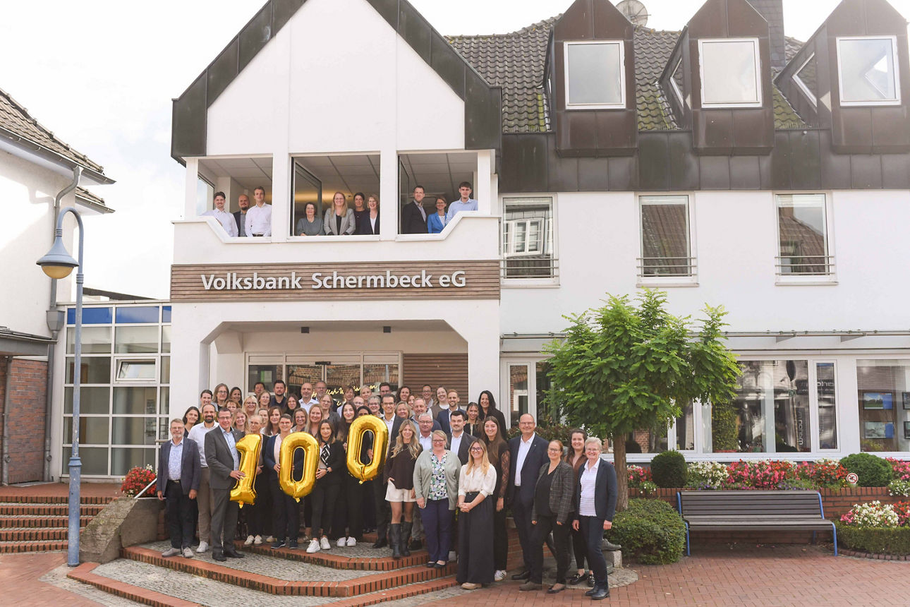 Gruppenbild der Mitarbeiter der Volksbank Schermbeck vor dem Hauptgebäude in Schermbeck