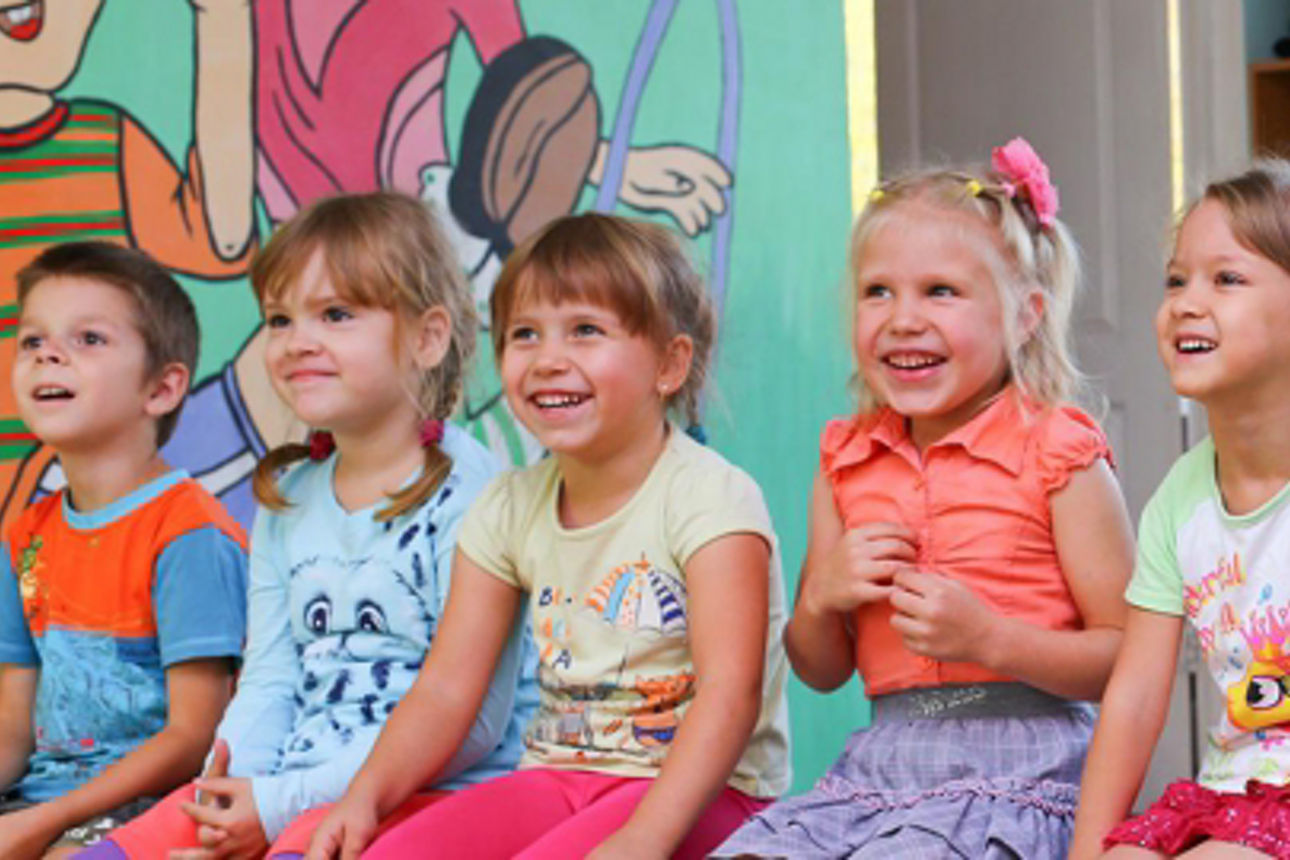 Eine Gruppe von Kindern im Vorschulalter ist mit einer spielerischen Aktivität beschäftigt, ihre Gesichter strahlen vor Freud